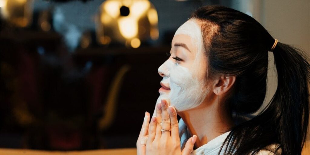 Woman applying a face mask.